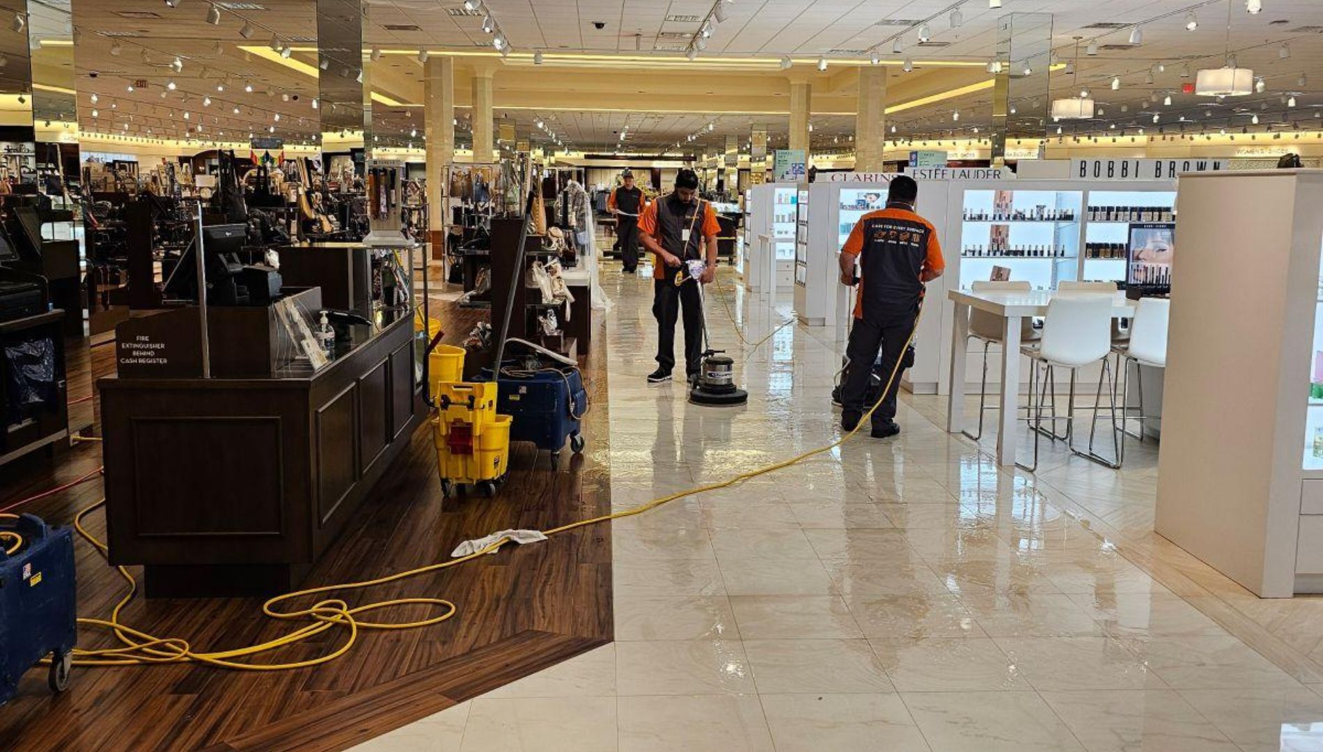 Men in a department store polishing and cleaning a walking path.