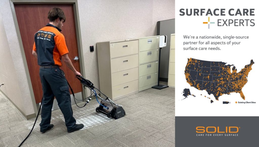 Man cleaning carpet floor in a commercial building.