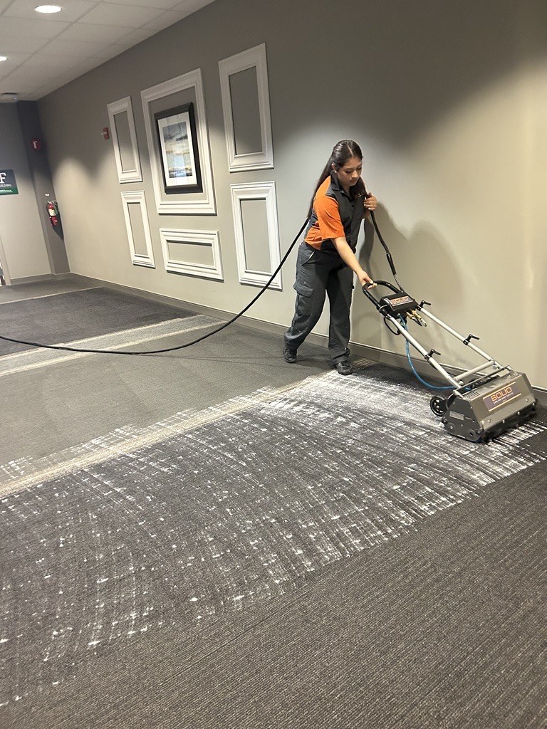 SOLID technician deep cleaning carpet in a commercial corridor