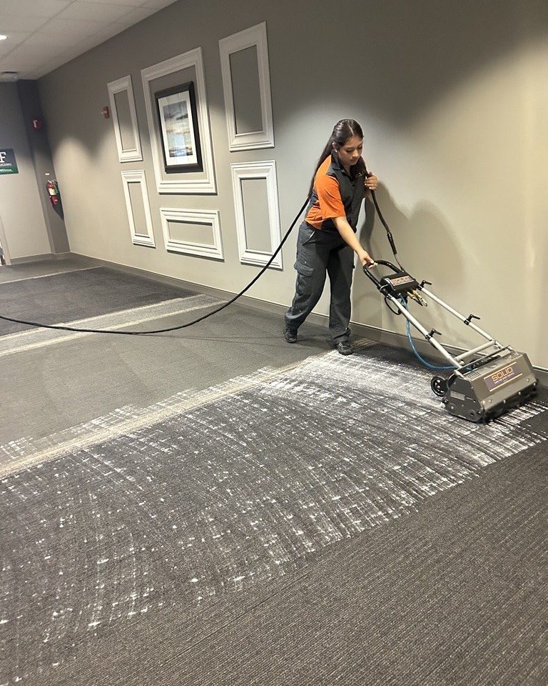 SOLID technician deep cleaning carpet in a hotel corridor