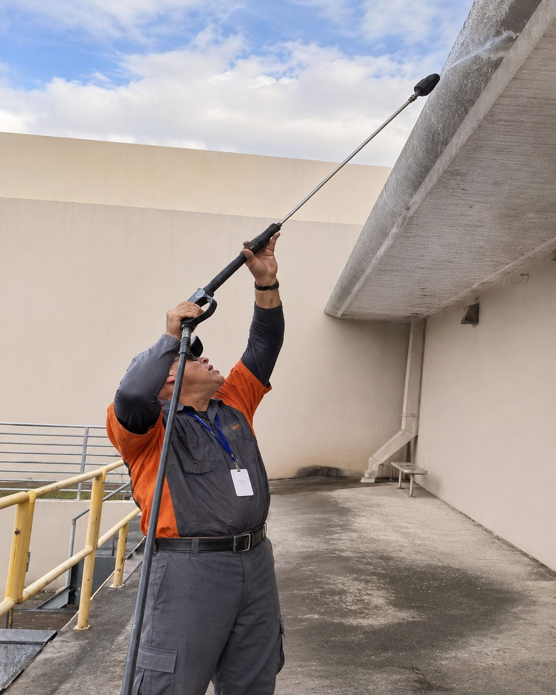 SOLID technician powerwashing a concrete overhang outside a commercial building